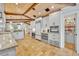 Bright open kitchen with an island bar, wooden ceiling beams, stainless steel appliances, and walk-in pantry at 940 Lincoln Cir, Winter Park, FL 32789
