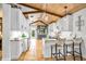 Bright kitchen with white cabinets, tiled backsplash, granite counters, and a breakfast bar with straw stools at 940 Lincoln Cir, Winter Park, FL 32789