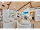 Bright living room with wood-beamed ceilings, white furnishings, and fireplace with flatscreen TV at 940 Lincoln Cir, Winter Park, FL 32789