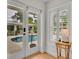 A sunlit pool patio is visible through a patio door and window with white shutters at 940 Lincoln Cir, Winter Park, FL 32789