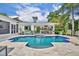 Backyard pool area with a built-in outdoor kitchen, lounge seating, and tiled deck at 940 Lincoln Cir, Winter Park, FL 32789