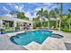 Beautiful backyard pool area with an outdoor kitchen, seating, and tropical landscaping at 940 Lincoln Cir, Winter Park, FL 32789