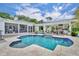 Backyard pool with an outdoor kitchen, screened-in porch, and lush landscaping at 940 Lincoln Cir, Winter Park, FL 32789