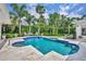 Backyard pool surrounded by lush tropical landscaping and a tiled patio area at 940 Lincoln Cir, Winter Park, FL 32789
