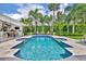 Sparkling blue backyard pool surrounded by lush tropical landscaping, a paved patio, and outdoor seating at 940 Lincoln Cir, Winter Park, FL 32789