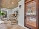 Inviting front porch with rocking chairs, wood ceiling, and decorative stained-glass front door at 940 Lincoln Cir, Winter Park, FL 32789