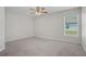 Bright bedroom featuring a ceiling fan, neutral carpet, and a window with blinds at 1119 Union Ave, Mascotte, FL 34753