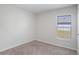 This bedroom features neutral walls and carpet, and a window providing natural light at 1119 Union Ave, Mascotte, FL 34753