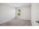 This bedroom features neutral walls and carpet, and a window providing natural light at 1119 Union Ave, Mascotte, FL 34753