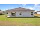 Back exterior of the property with covered patio, large windows, and a well-manicured lawn at 1119 Union Ave, Mascotte, FL 34753