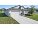 Well-manicured lawn complements the modern single Gathering home, complete with a two-car garage and inviting entrance at 1119 Union Ave, Mascotte, FL 34753