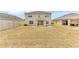 Expansive backyard, partially dry lawn, featuring a sliding door patio entrance and fenced yard at 116 Green Branch Blvd, Groveland, FL 34736