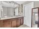 Well-lit bathroom featuring a double vanity, dark wood cabinets, and modern fixtures at 116 Green Branch Blvd, Groveland, FL 34736