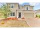 Inviting two-story home featuring a brick-paved driveway, attached two-car garage and manicured landscaping at 116 Green Branch Blvd, Groveland, FL 34736