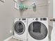 Well-equipped laundry room featuring a modern washer and dryer, plus shelving for storage and supplies at 116 Green Branch Blvd, Groveland, FL 34736