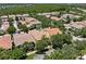 Overhead view of townhomes with terracotta roofs, landscaped yards, surrounded by mature trees and green spaces at 11918 Nautica Dr, Orlando, FL 32827