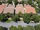 Aerial view of charming townhomes featuring tile roofs, lush landscaping and mature trees enhancing the community at 11918 Nautica Dr, Orlando, FL 32827
