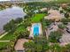Aerial view showcasing a community pool near a lake with mature trees and landscaping at 11918 Nautica Dr, Orlando, FL 32827