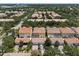 An aerial view of vibrant townhomes with private garages, screened patios, lush surroundings, and tile roofing at 11918 Nautica Dr, Orlando, FL 32827