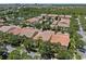 An aerial view capturing townhomes with tile roofs, private garages, screened patios, and lush landscapes at 11918 Nautica Dr, Orlando, FL 32827