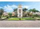 Elegant clubhouse featuring a clock tower, manicured landscaping, and brick-paved entrance at 11918 Nautica Dr, Orlando, FL 32827