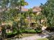 Inviting yellow townhome with mature landscaping, palm trees, and a red tiled roof at 11918 Nautica Dr, Orlando, FL 32827
