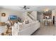Open-concept living room with neutral tones, a ceiling fan, and staircase access to the second level at 11918 Nautica Dr, Orlando, FL 32827