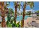 Resort-style community pool with tropical landscaping, lounge chairs, and seating areas under blue umbrellas at 11918 Nautica Dr, Orlando, FL 32827