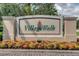 Elegant entrance sign for Village Walk community, surrounded by colorful landscaping on a sunny day at 11918 Nautica Dr, Orlando, FL 32827