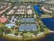 Aerial shot showcases four well-maintained tennis courts surrounded by lush landscaping and a serene lake at 11918 Nautica Dr, Orlando, FL 32827