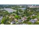 Scenic aerial view of a residential neighborhood with mature trees, backyard pools and a lake in the distance at 1245 Munster St, Orlando, FL 32803