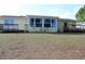 A view of the backyard featuring a well-maintained lawn and back porch at 1364 Gainesville Dr, Deltona, FL 32725