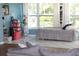 Light and airy bedroom with lots of natural light featuring a bed with gray covers and white curtains at 1364 Gainesville Dr, Deltona, FL 32725