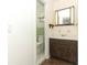 View of a bathroom featuring a wood vanity and framed mirror, with the toilet in an adjacent area at 1405 Paula Dr, Apopka, FL 32703