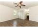 Sunlit bedroom with wood floors, a ceiling fan, a window, and closet doors leading to the bathroom at 1405 Paula Dr, Apopka, FL 32703