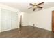 Bright bedroom featuring dark wood flooring, ceiling fan, and closet with louvered doors at 1405 Paula Dr, Apopka, FL 32703