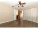 Bedroom with hardwood flooring and ceiling fan, leading to ensuite bathroom at 1405 Paula Dr, Apopka, FL 32703