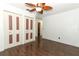 Empty bedroom featuring dark wood floors, white walls, and a ceiling fan at 1405 Paula Dr, Apopka, FL 32703