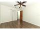 Bedroom with wood-look flooring, ceiling fan, closet, and doorway at 1405 Paula Dr, Apopka, FL 32703