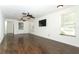 Bright and spacious living room with dark wood floors, ceiling fans, and ample windows at 1405 Paula Dr, Apopka, FL 32703