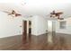 Open-concept living room with dark wood floors and multiple ceiling fans at 1405 Paula Dr, Apopka, FL 32703