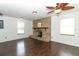 Living room showcasing brick fireplace, wood floors, and natural light at 1405 Paula Dr, Apopka, FL 32703