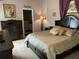 Bedroom with a large, dark-wood bed frame, neutral carpet, and matching furniture at 1585 Stefan Cole Ln, Apopka, FL 32703