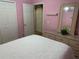 Bright bedroom with a bed, dresser with mirror, closet and pink walls at 1585 Stefan Cole Ln, Apopka, FL 32703