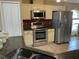 Well-lit kitchen featuring stainless steel appliances, granite countertops, tiled backsplash, and ample cabinet space at 1585 Stefan Cole Ln, Apopka, FL 32703