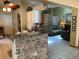 Open-concept kitchen with a stone bar, flowing into a cozy living room area with comfortable seating and warm lighting at 1585 Stefan Cole Ln, Apopka, FL 32703