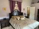 Comfortable main bedroom with a large bed, decorative pillows, and elegant furnishings at 1585 Stefan Cole Ln, Apopka, FL 32703