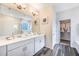 Bathroom featuring a double sink vanity with white countertop, framed mirror, and a walk-in closet with shelving at 1974 Walnut Creek Dr, Kissimmee, FL 34744
