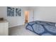 Neutral bedroom with carpeted floors features a bed with navy blue bedding and white walls with framed artwork at 1974 Walnut Creek Dr, Kissimmee, FL 34744