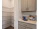 Pantry with wire shelving, gray cabinets, and cookbook on the countertop at 1974 Walnut Creek Dr, Kissimmee, FL 34744